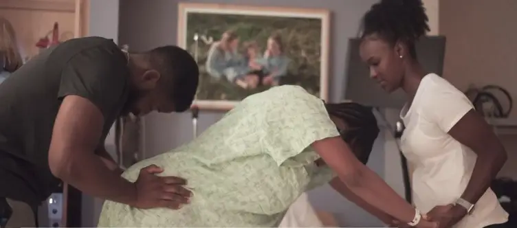 A woman in labor with husband and a doula