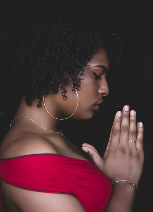 A woman in a red dress is praying