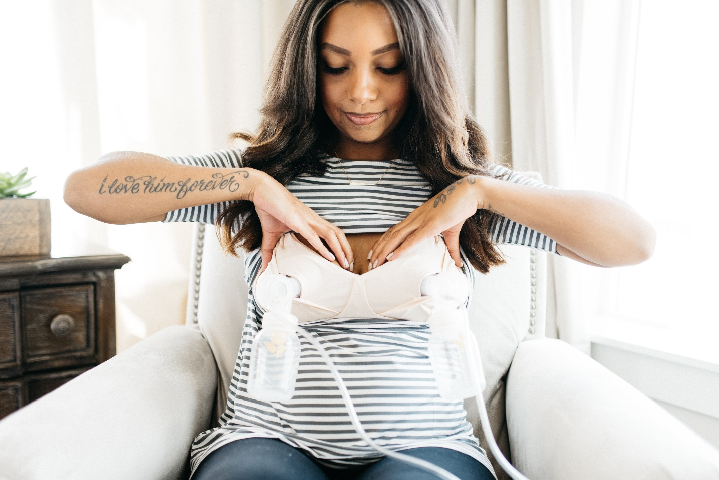 Postpartum mother using an electric breast pump during early breastfeeding and milk expression