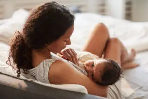 Mother breastfeeding her newborn baby during the early days of postpartum bonding and feeding
