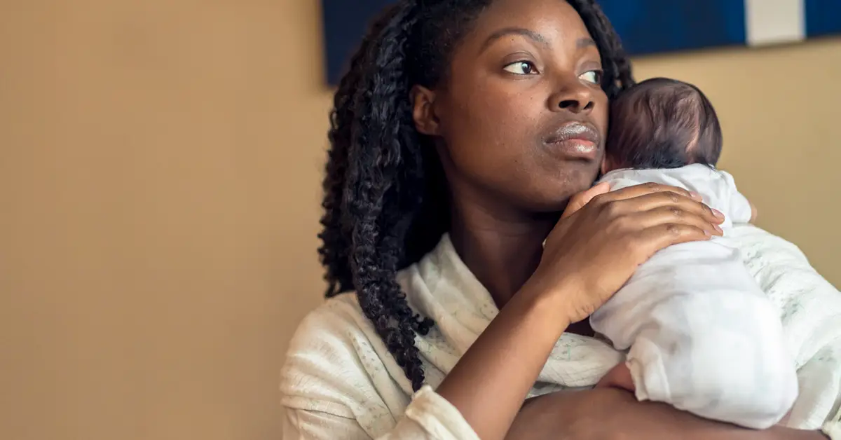 Mother holding her newborn baby close after birth