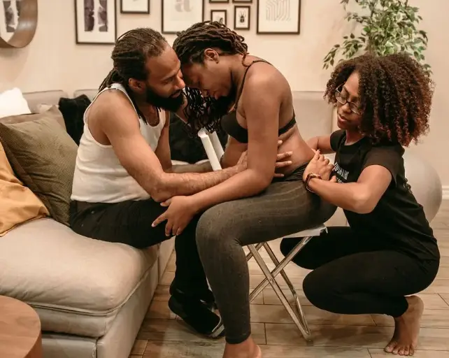 Doula and partner providing physical and emotional support to a laboring mother
