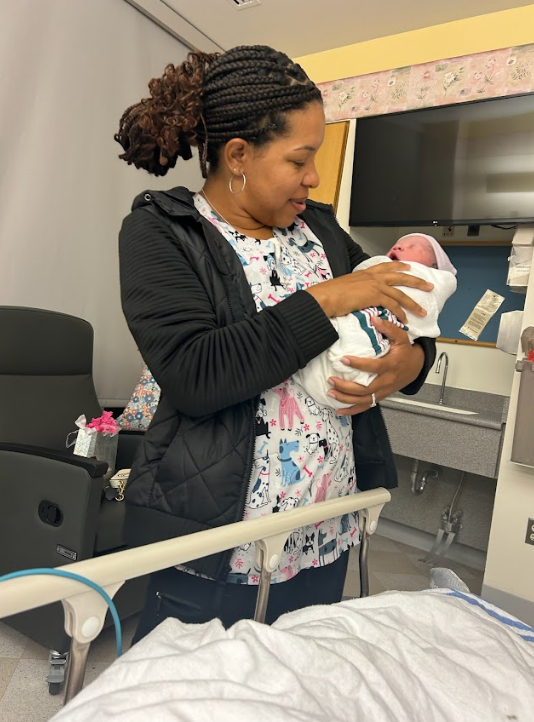  Doula, Nikkita Jervey, holding a newborn baby and supporting a family during the first hours after birth