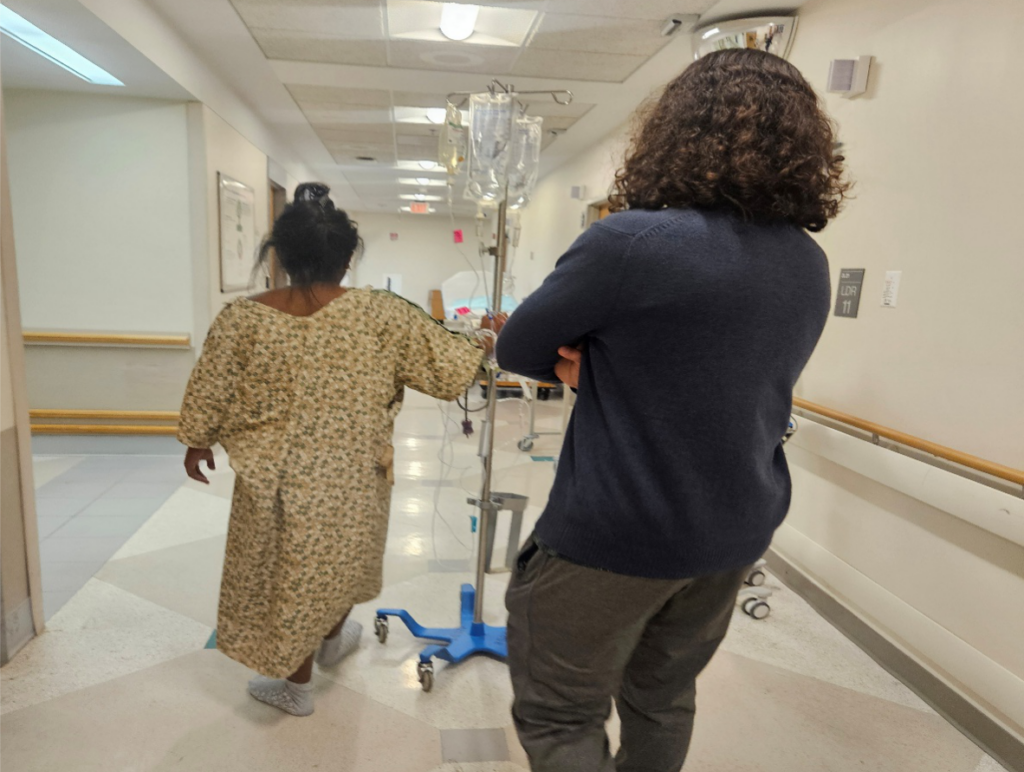 Pregnant mother walking the hospital halls with her husband during a labor induction to encourage labor progression