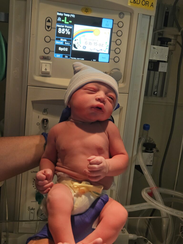 Newborn baby being weighed shortly after birth in the hospital