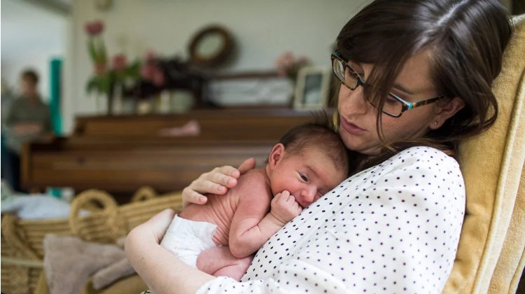 New mother holding her newborn during the early postpartum weeks